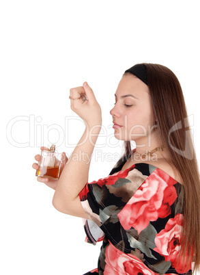 Teenager girl smelling the perfume on her wrist