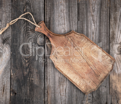 very old brown  cutting board with a handle