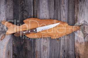 old wooden board in the form of a fish figure and a knife