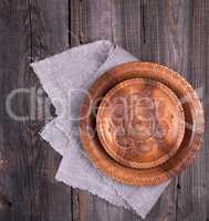 empty round brown carved decorative plate standing on a gray lin