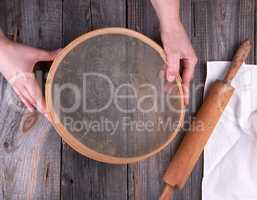 female hands holding a round wooden sieve for flour