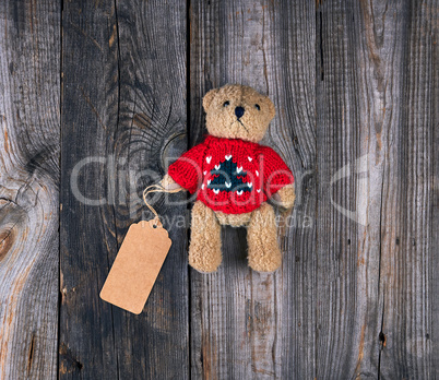small brown old teddy bear with a paper blank tag