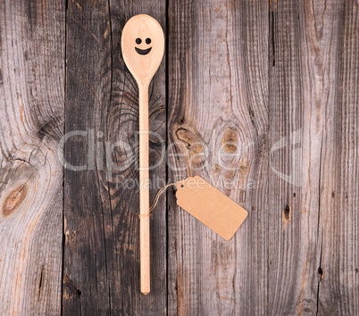 wooden spoon with embedded eyes and a smile, empty brown paper t