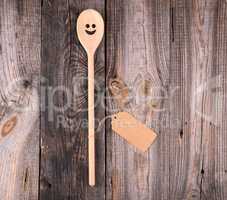 wooden spoon with embedded eyes and a smile, empty brown paper t