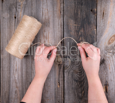 female hands holding a brown rope