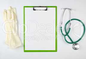 black medical stethoscope and green paper holder
