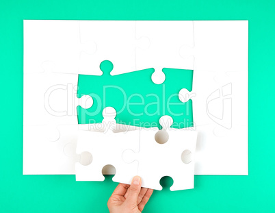 female hand puts empty white big puzzles