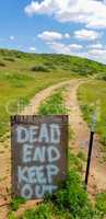 Dead End Keep Out Sign On Wire Fence At Dirt Road