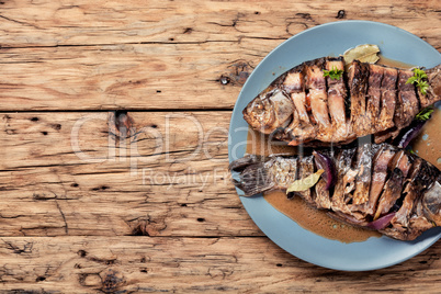 Roasted fish on wooden background