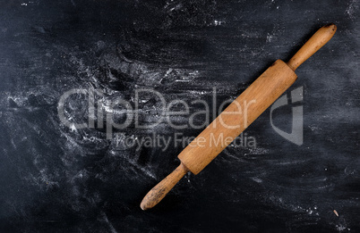 wooden rolling pin on a black background