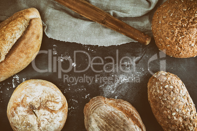 baked various loaves of bread on a black background