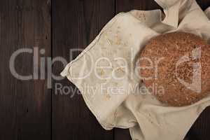 baked round rye bread with sunflower seeds on a beige textile na