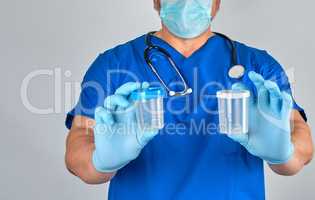 doctor in blue uniform and latex gloves is holding an empty plas