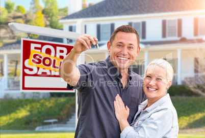 Happy Couple With New House Keys In Front of Sold Real Estate Si