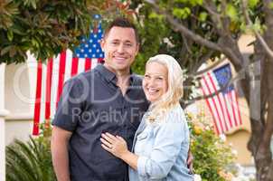 Happy Couple In Front of Houses with American Flags