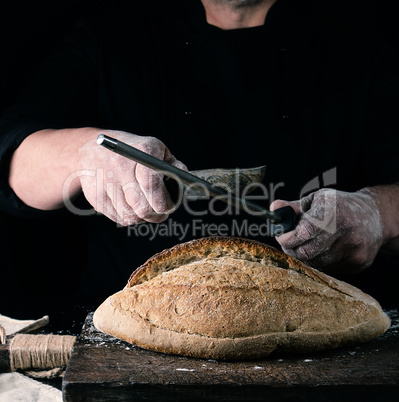 chef in black uniform sharpens a kitchen knife