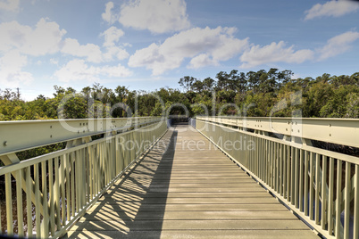 Blue sky and clouds over a bridge that crosses Henderson Creek,
