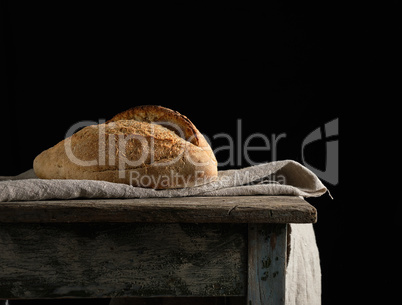 Baked white wheat flour oval crispbread on a wooden board