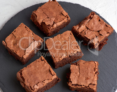 pieces of chocolate brownie on a black round graphite plate