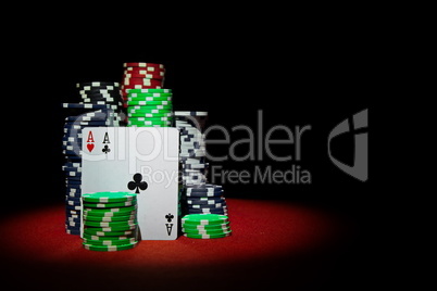 Stack of Chips with cards pair of aces on red table