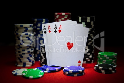Four aces with a lot of chips on the poker table.