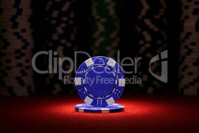 Closeup of blue poker chip on red felt card table surface with spot light on chip