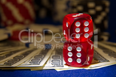Stack of Poker chips with dice rolls on a dollar bills,