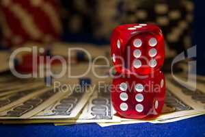 Stack of Poker chips with dice rolls on a dollar bills,
