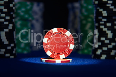 Closeup of poker chips on green felt card table surface