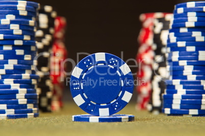 Closeup of poker chips on green felt card table surface