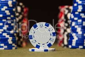 Closeup of poker chips on green felt card table surface