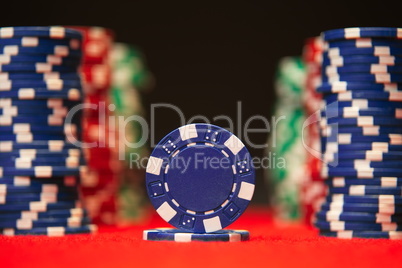 Closeup of poker chips on red felt card table surface
