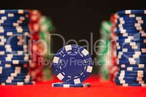 Closeup of poker chips on red felt card table surface