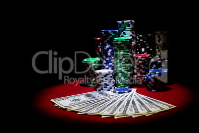 Dollars and poker chips on red casino table