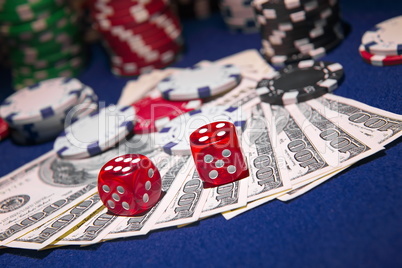 Stack of Poker chips with dice rolls on a dollar bills,