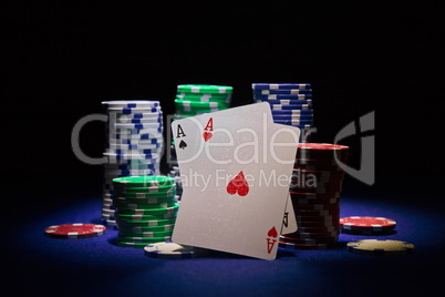 Pair of aces and poker chip on black background
