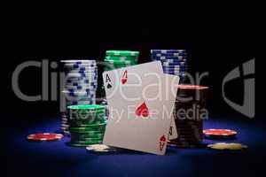 Pair of aces and poker chip on black background