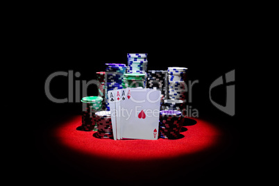 Four aces with gambling chips on red casino table