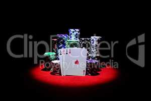 Four aces with gambling chips on red casino table