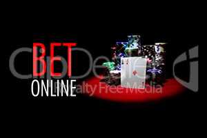 Poker cards , dollars and gambling chips on red table with message BET ONLINE