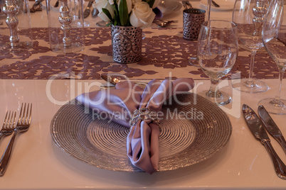 Purple place setting with a lilac colored napkin, white roses