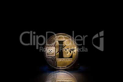 Litecoin (LTC) token, standing upright on a reflective black background