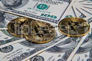 Bitcoins and dollars on office desk