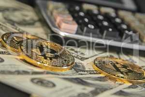Bitcoins and dollars with calculator in background