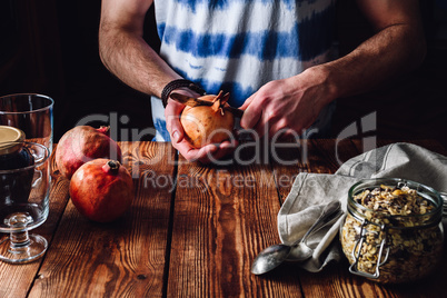 Man Opens Pomegranate with a Knife.