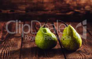 Two green pears on wooden background