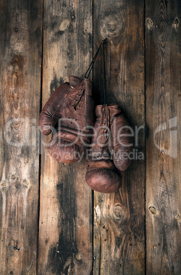 very old leather brown boxing gloves hang