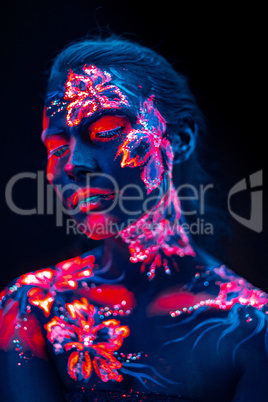 Beautiful flowers in UV light on a young girl face and body