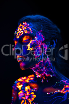 Beautiful flowers in UV light on a young girl face and body