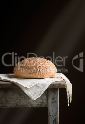 baked round rye bread lies on a gray linen napkin